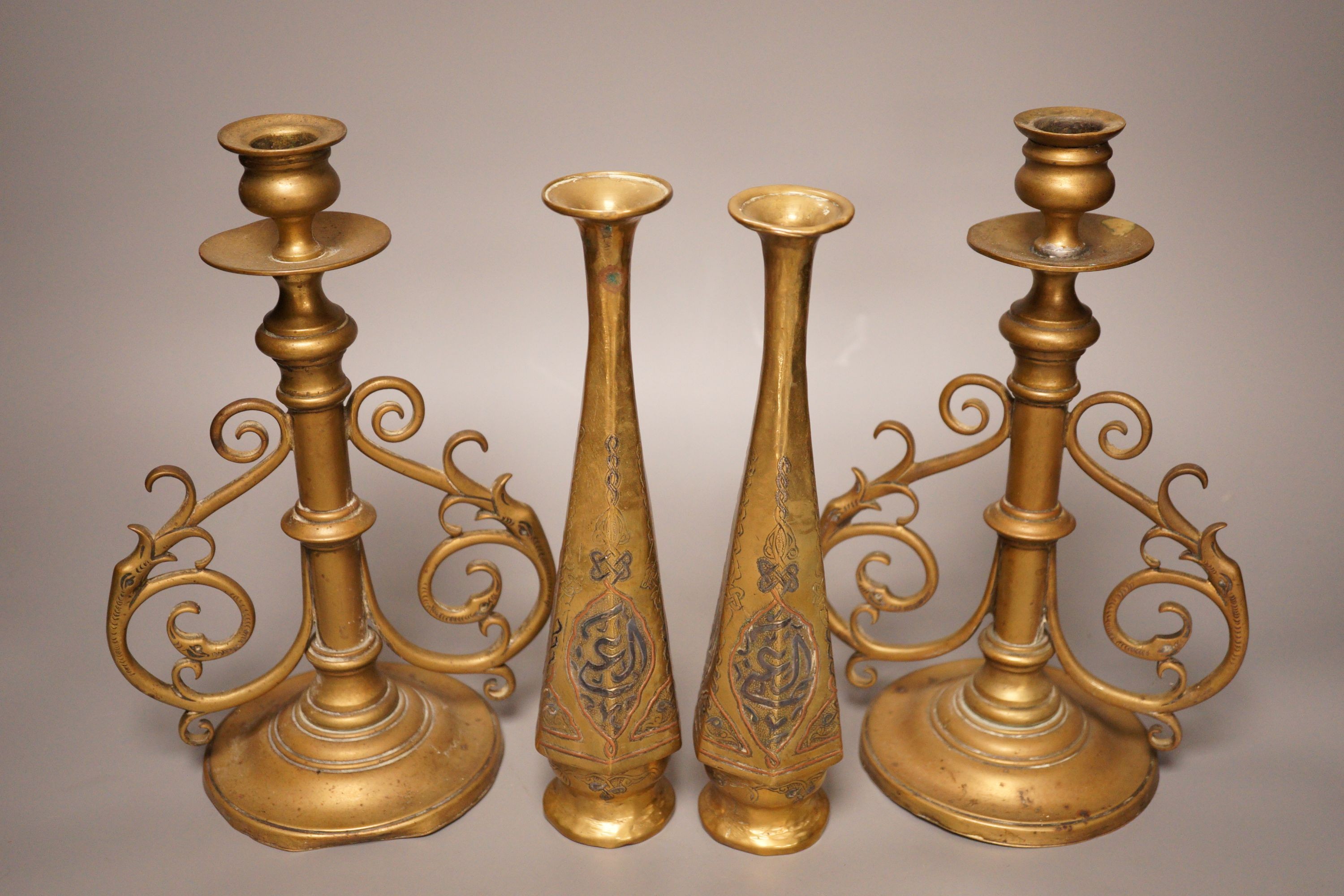 A pair of Victorian brass candlesticks and a pair of Arabic brass posy vases, tallest 25cm